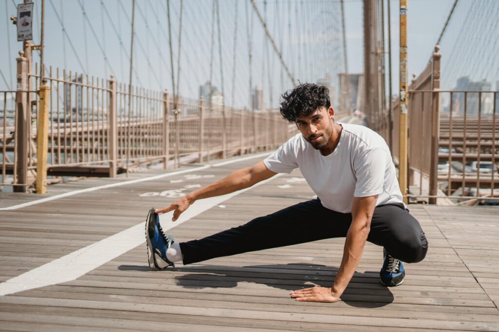 Man stretching on bridge before morning run